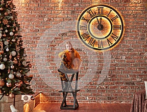 Cute girl sitting in the living room with Christmas decor