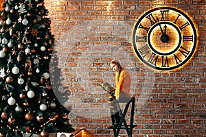 Cute girl sitting in the living room with Christmas decor