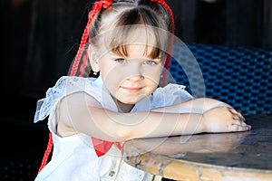 cute girl sitting at a table in kafe in the summer