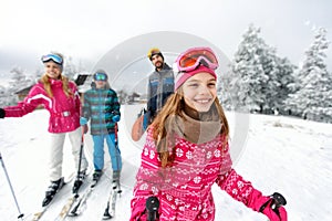 Girl skier skiing with family on mountain