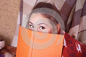 Cute girl on the sofa with a book