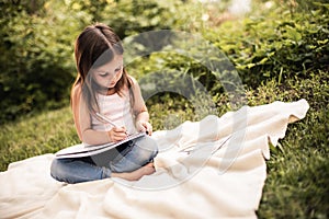 Cute girl spending time and sitting on grassland photo