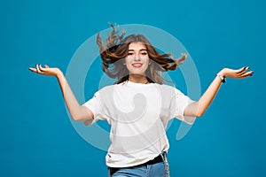 Cute girl student teenager with flying hair and a smile on his face on a blue background. The concept of happiness, carefree and