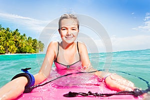 Cute girl swimming on board near tropical island