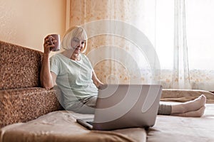 Cute girl talking with her grandmother within video chat on laptop, life in quarantine time