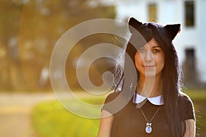 Cute girl with toy cat ears on head in sunbeam light