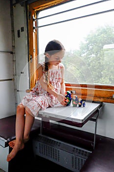 Cute girl in the train. Summer Vacation and Travel Concept. A girl of 5 or 6 years old rides on a train. Teen travels