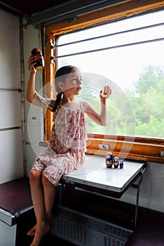 Cute girl in the train. Summer Vacation and Travel Concept. A girl of 5 or 6 years old rides on a train. Teen travels