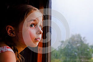 Cute girl in the train. Summer Vacation and Travel Concept. A girl of 5 or 6 years old rides on a train. Teen travels