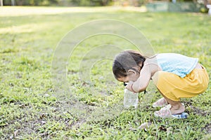 Cute girl using magnifying glass to look at bugs in glass jars Learn to use science-related observations