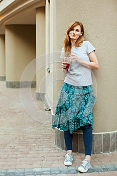 Cute girl walking around city with lemonade