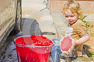 Small girl washing car