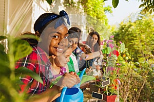 Cute girl with watering can working in garden