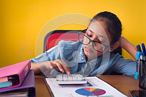 Cute girl wearing glasses is boring with hard work on the desk isolated on yellow background
