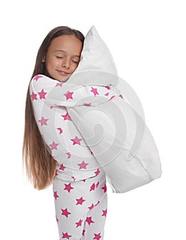 Cute girl wearing pajamas with pillow on white background