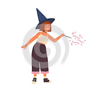 Cute girl wearing witch hat conjuring with magic wand. Portrait of young female wizard or sorcerer. Adorable child