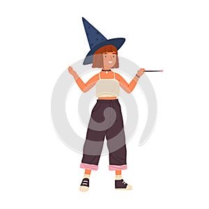 Cute girl wearing witch hat and holding magic wand. Young female wizard. Portrait of funny teenage magician with red