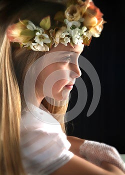 Cute girl in white dress holding flower.