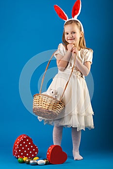 Cute girl with White rabbit in basket with Easter eggs