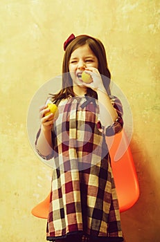 Cute girl with winking eyes eating lemons