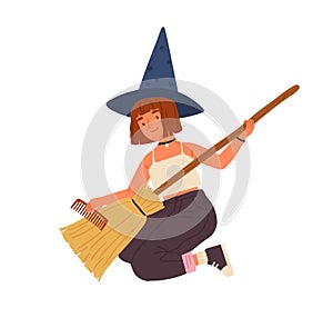 Cute girl in witch hat sitting and combing broom. Young female magician or wizard portrait. Funny sorcerer with red hair