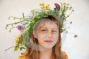 Cute girl with  wreath of summer wild flowers