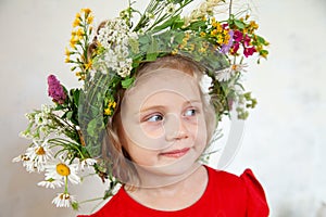 Cute girl with  wreath of summer wild flowers