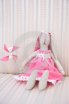 Cute girlish toy of a rabbit in white dotted dress