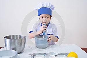 Cute girls with amazing smile in clothes and chef cap. Cooking on kitchen cake. Kids make cookie at home, Children do dessert with