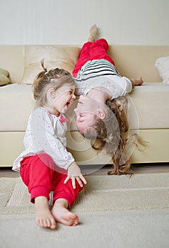 Cute girls on the couch upside down