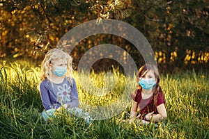 Cute girls friends in sanitary masks on faces. Preschool children kids wearing protective masks against coronavirus. Social