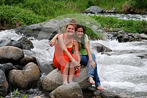 Cute girls sitting by rapids photo