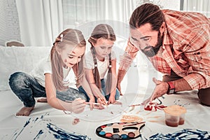 Cute girls and their dad drawing in light bedroom photo