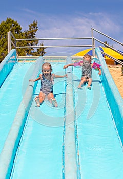 Cute girls on water slide at aquapark during