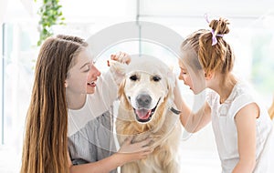 Cute girls whispering into dog`s ears