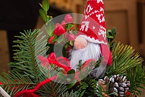 Cute gnome toy on Christmas tree. Small dwarf doll in red hat. Santa Claus doll on Christmas market. Christmas market.