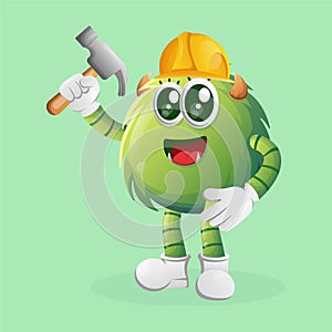 Cute green monster builder holding hammer