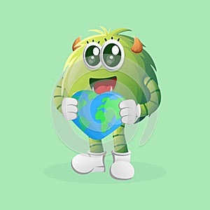 Cute green monster holding earth with love shape