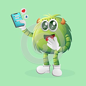 Cute green monster holding mobile phone with text messages
