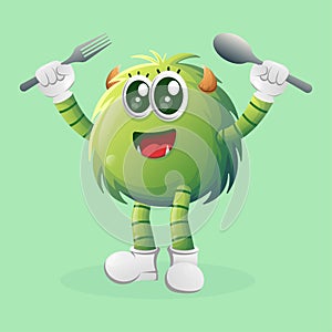 Cute green monster holding spoon and fork