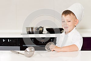 Cute grinning little boy in a chefs hat and apron