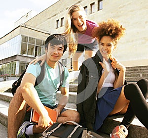 Cute group of teenages at the building of university with books