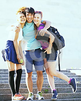 Cute group of teenages at the building of university with books