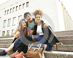 Cute group of teenages at the building of university with books