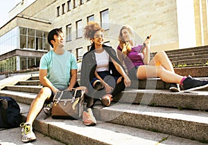 Cute group of teenages at the building of university with books