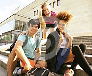 Cute group of teenages at the building of university with books