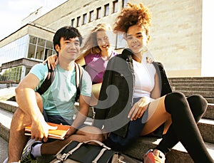 Cute group of teenages at the building of university with books