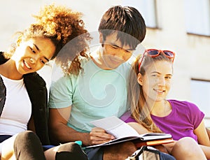 Cute group of teenages at the building of university with books huggings