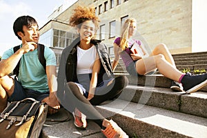 Cute group teenages at the building of university with books huggings