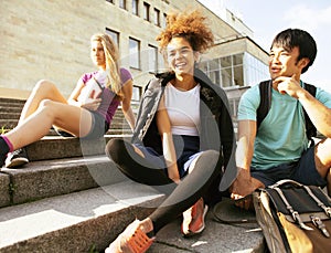 Cute group teenages at the building of university with books huggings